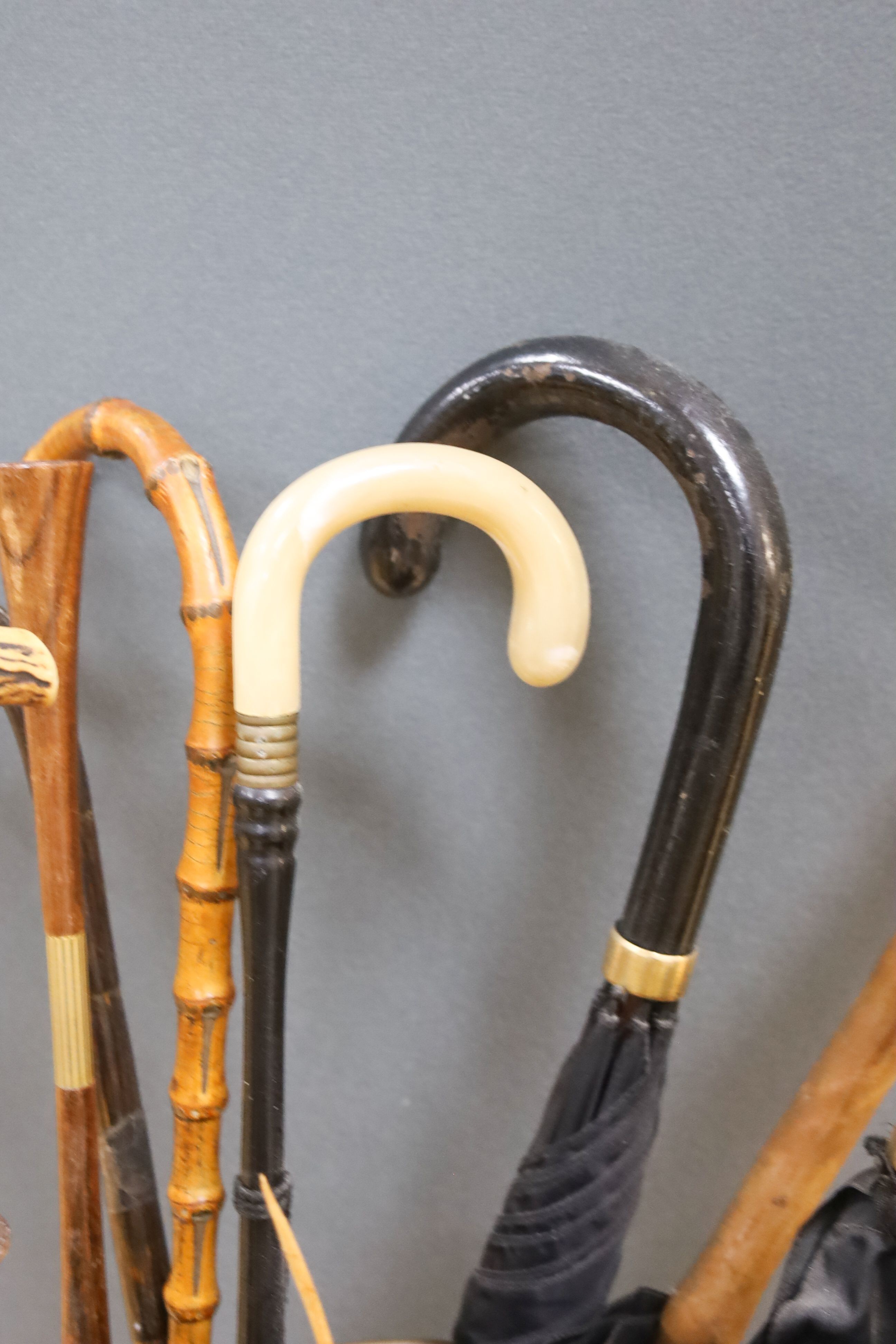A cylindrical repousse brass stick stand, with walking sticks, parasols, etc.